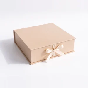 Closed champagne gift box tied with an ivory satin ribbon bow