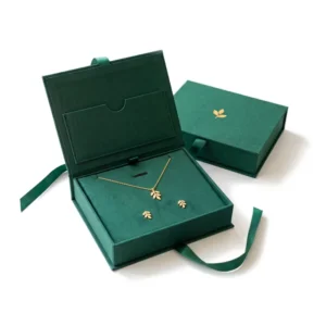 Emerald jewelry gift box open with a gold leaf necklace and earrings