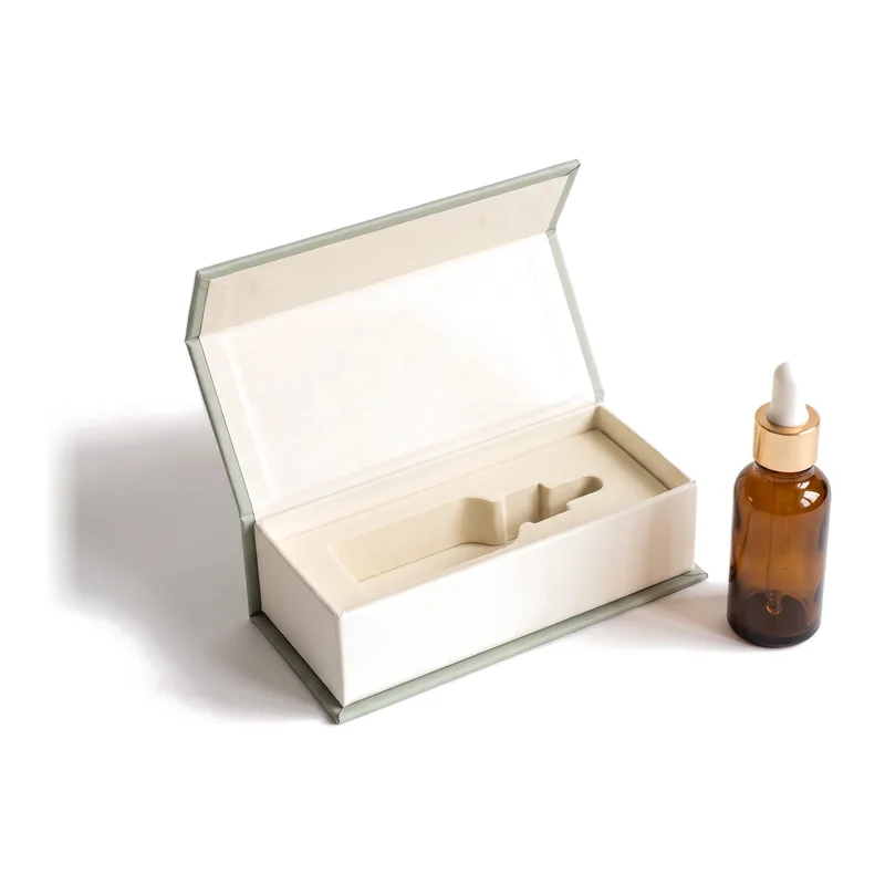 Ivory dropper bottle gift box with sage trim and an amber bottle beside it