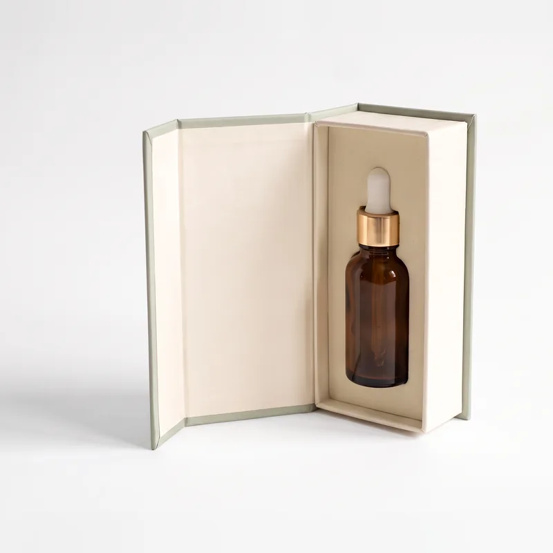 Ivory and sage dropper bottle box standing open with an amber bottle inside