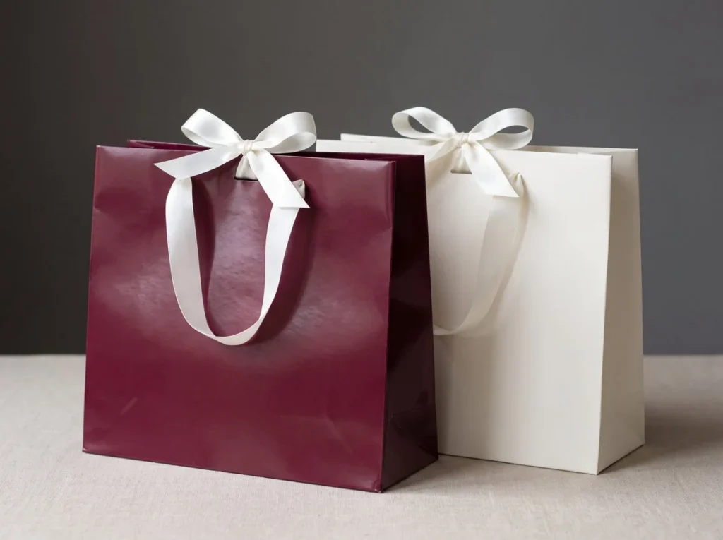 Burgundy and ivory paper gift bags with satin ribbon handles