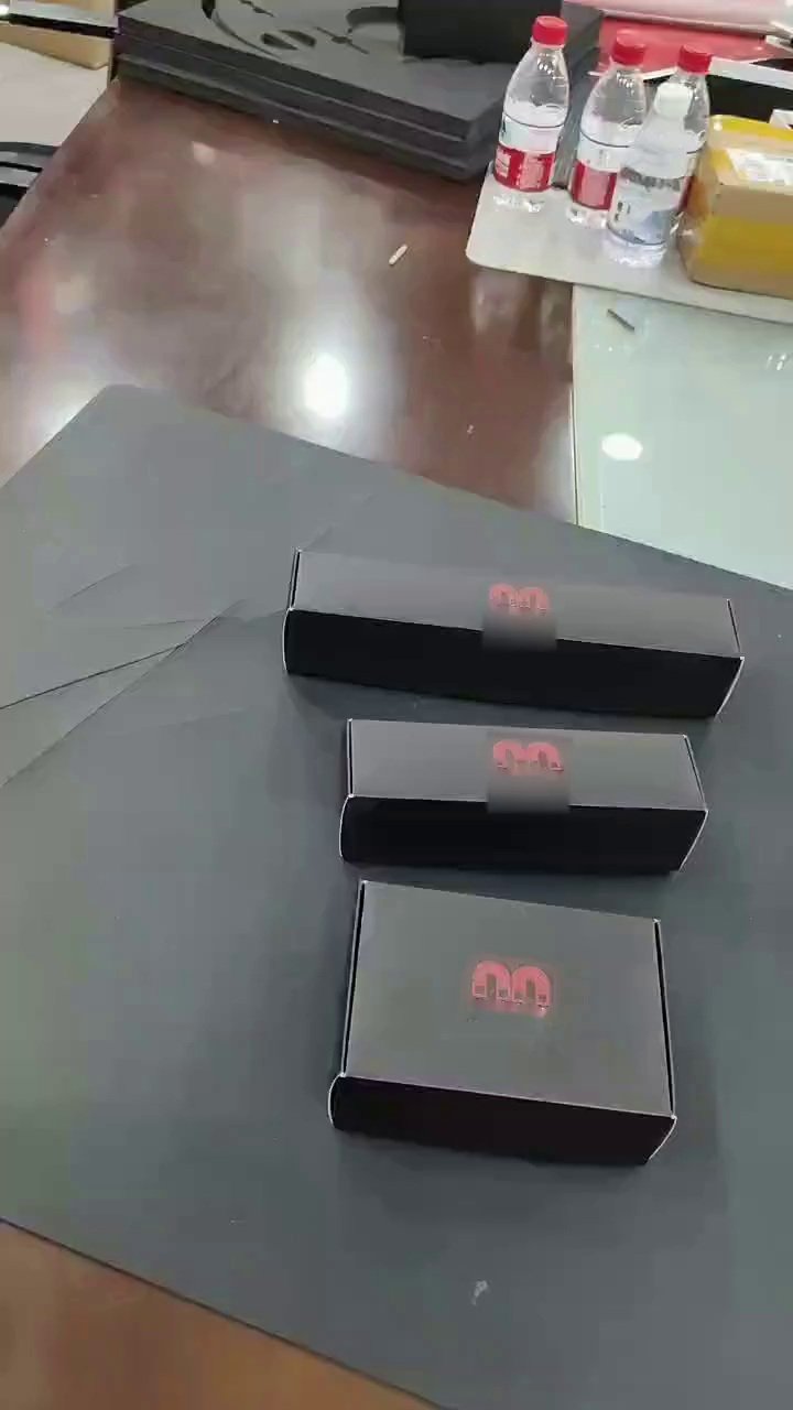 Three black carton samples with red emblems