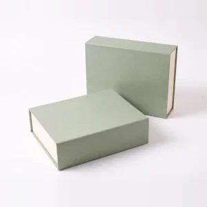 Two closed sage green magnetic boxes, one standing and one lying flat