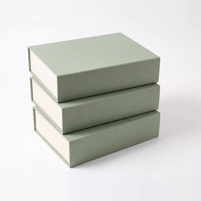 Three sage green presentation boxes stacked